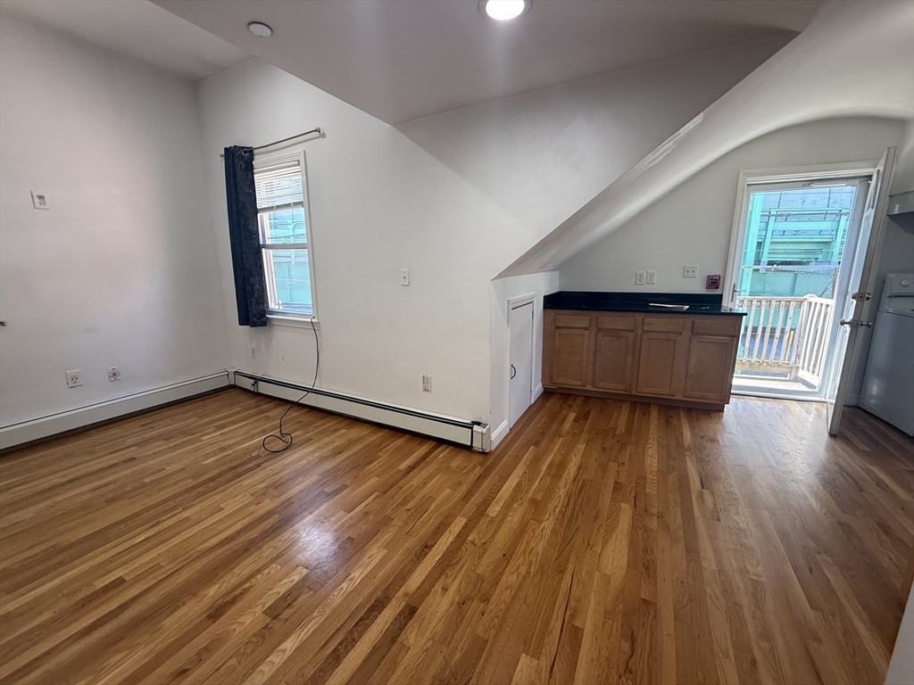 69 Beacon Street, Unit 3 Chelsea, MA 02150 - Photo 3 of 9 an empty room with wooden floor and windows