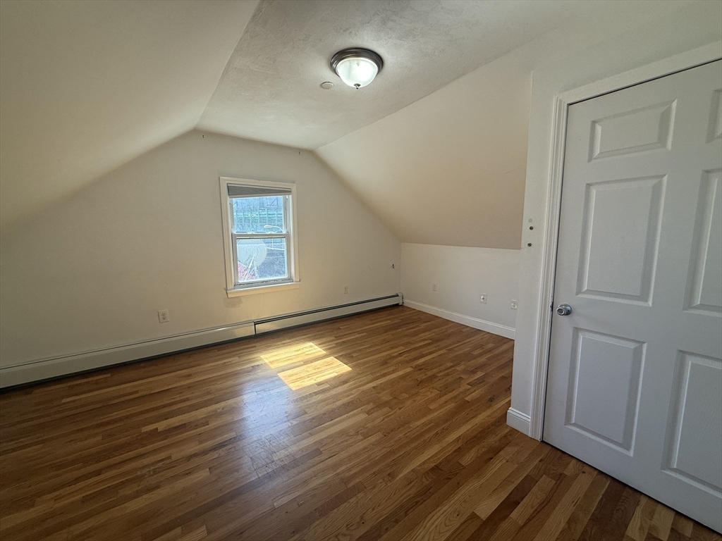 69 Beacon Street, Unit 3 Chelsea, MA 02150 - Photo 5 of 9 an empty room with wooden floor and windows