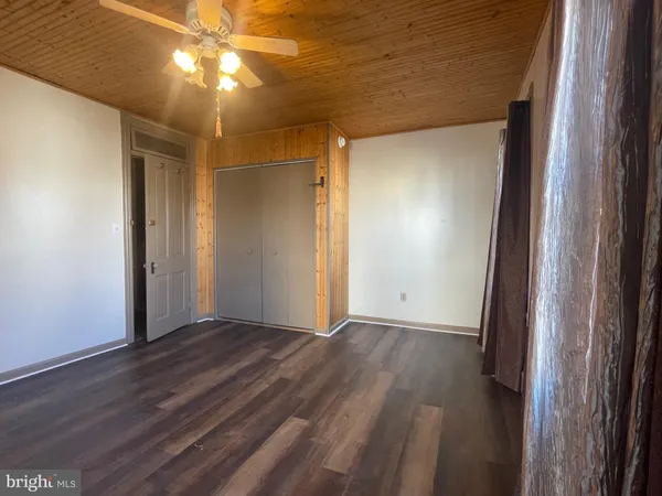 an empty room with wooden floor and closet