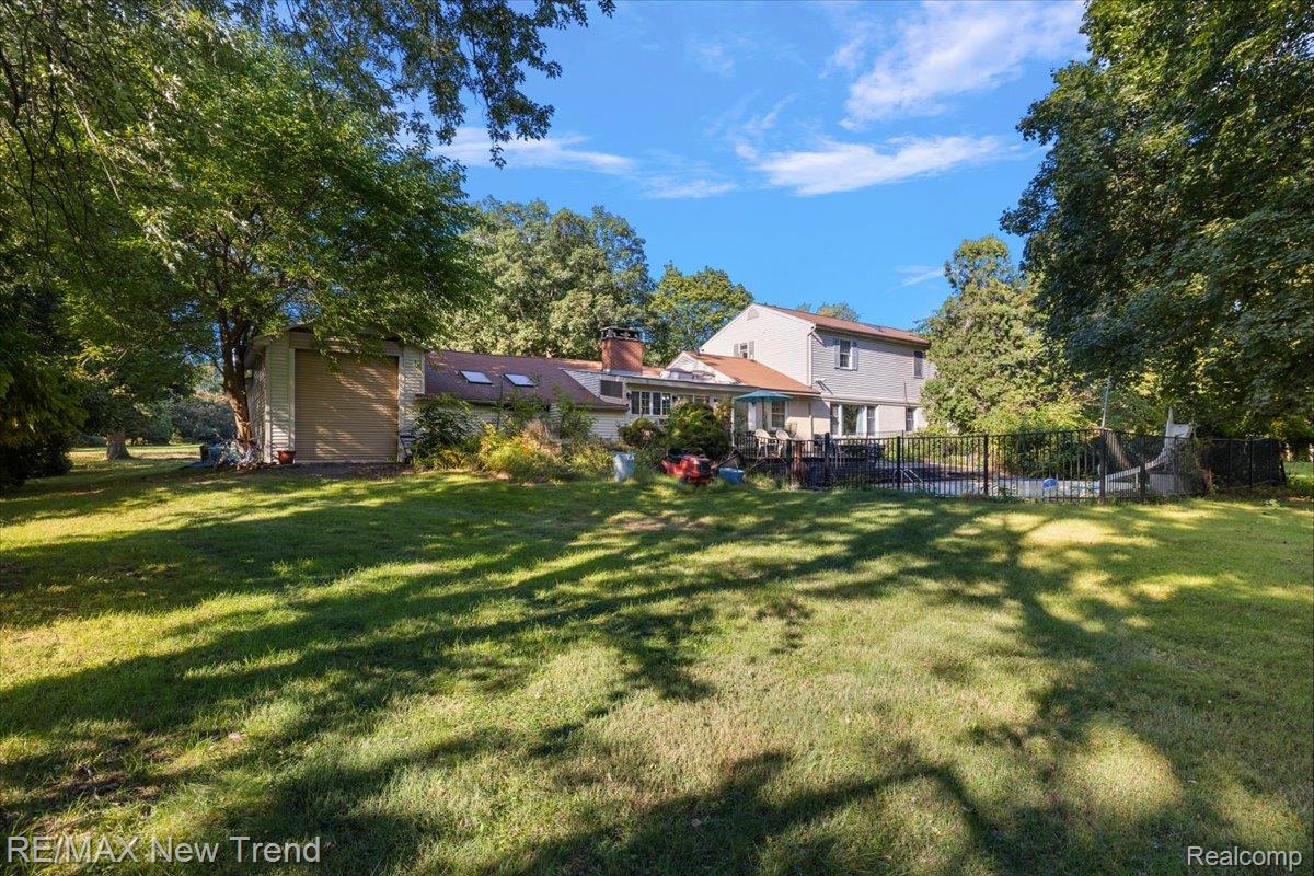 1450 Lenox Road Bloomfield Hills, MI 48304 - Photo 72 of 79 Expansive rear yard with mature trees, a fenced swimming pool, and a multi-level deck