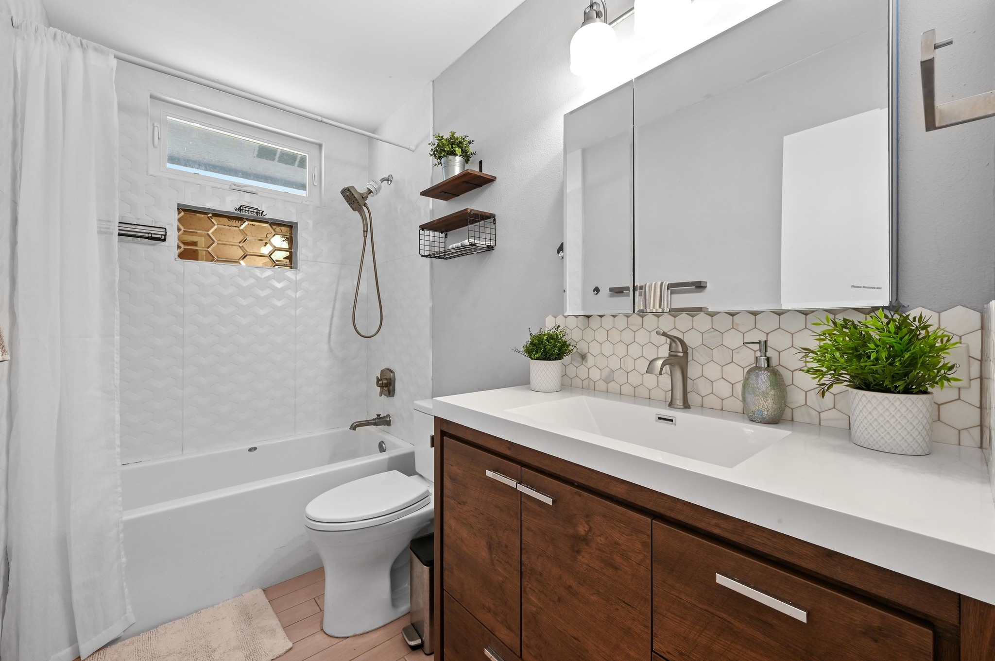 6302 Thurgood Avenue Austin, TX 78721 - Photo 15 of 28 Bathroom with shower / tub combo, vanity, tasteful backsplash, and light wood-type flooring