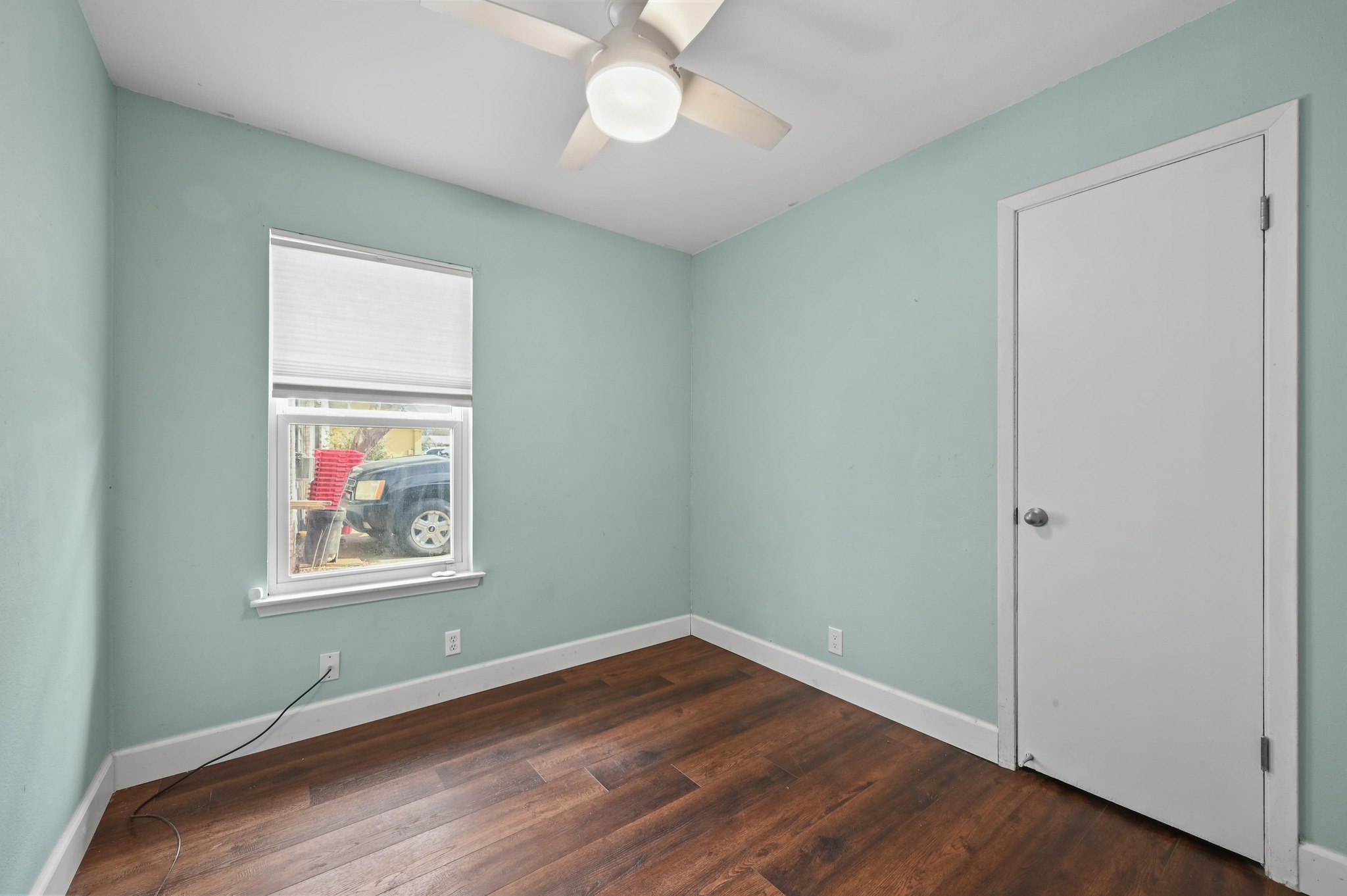 6302 Thurgood Avenue Austin, TX 78721 - Photo 16 of 31 an empty room with wooden floor ceiling fan and windows
