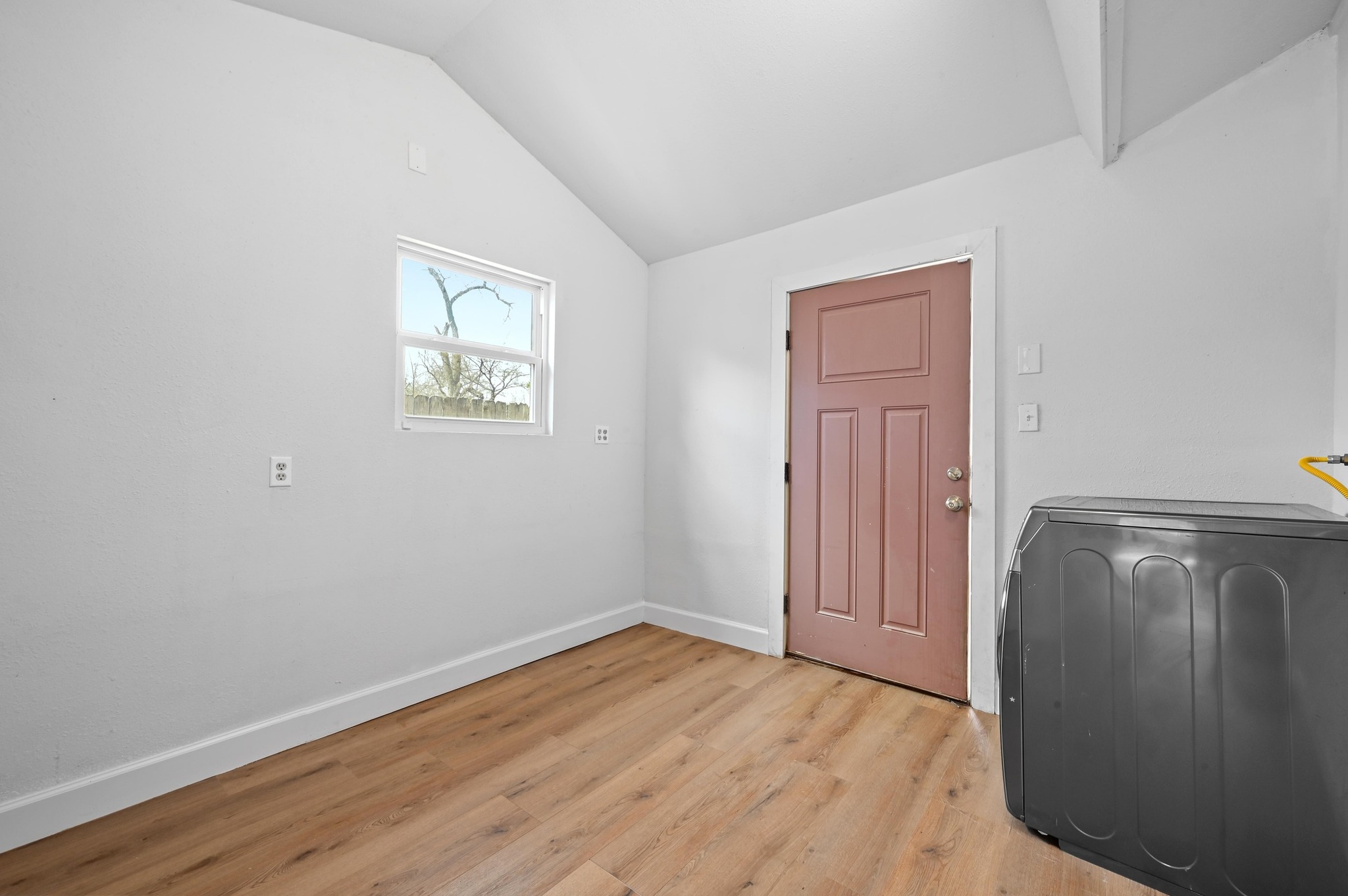6302 Thurgood Avenue Austin, TX 78721 - Photo 17 of 28 Large laundry room with vaulted ceiling and door to back patio/yard.