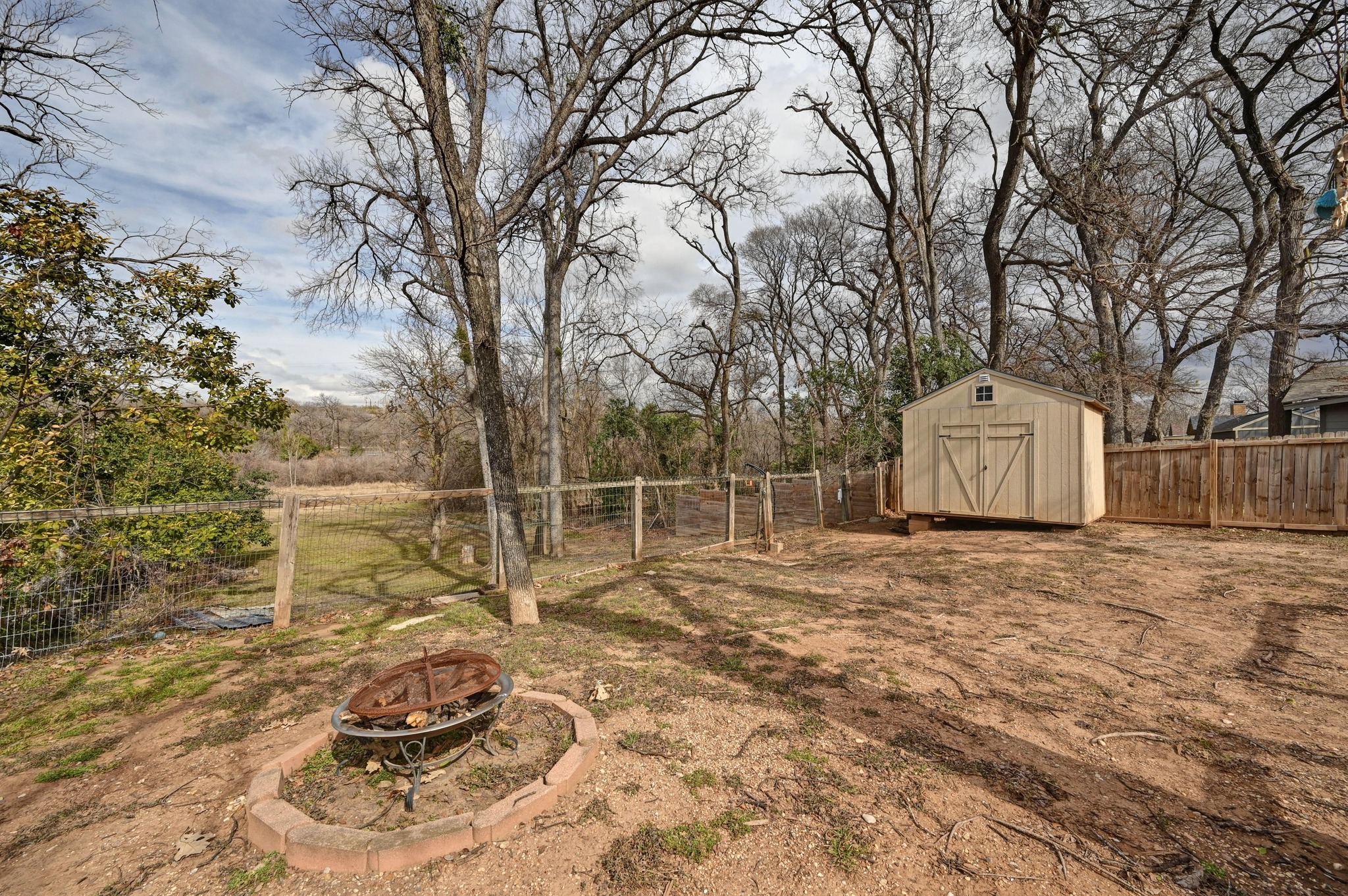 6302 Thurgood Avenue Austin, TX 78721 - Photo 21 of 28 Fenced backyard with an outdoor fire pit and a shed