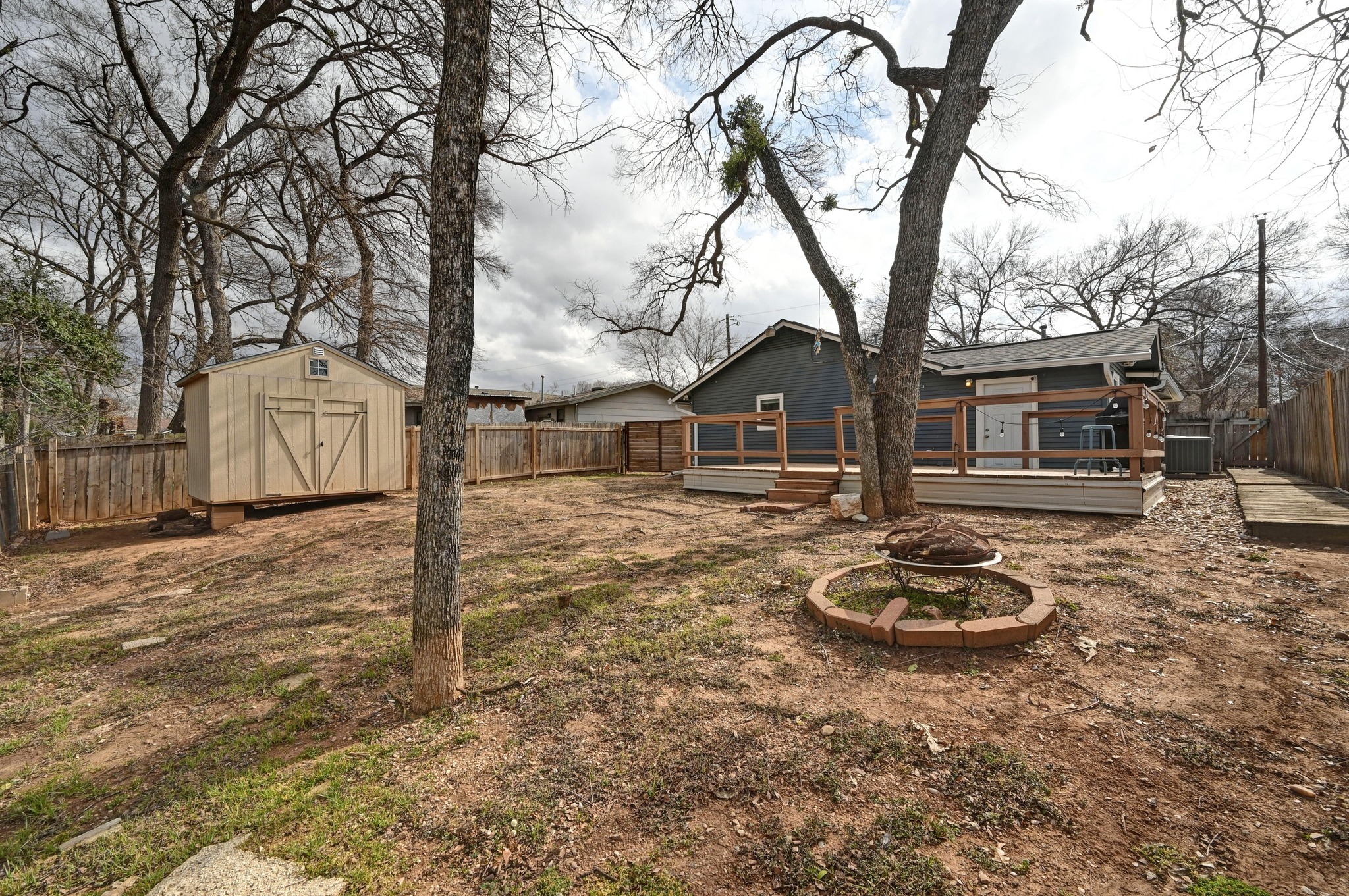 6302 Thurgood Avenue Austin, TX 78721 - Photo 22 of 28 Fenced backyard with a wooden deck and a storage shed