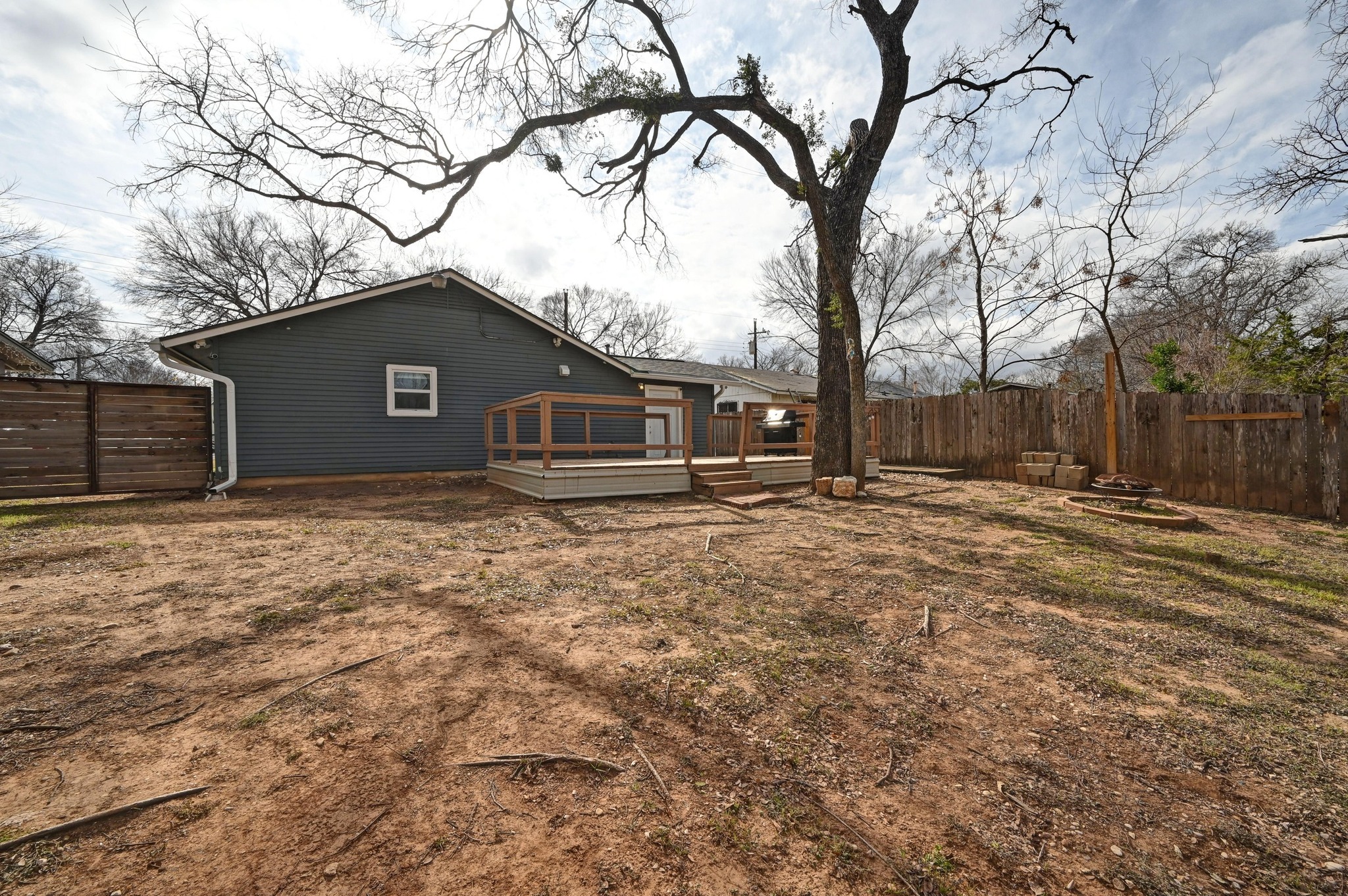 6302 Thurgood Avenue Austin, TX 78721 - Photo 23 of 28 Rear view of house with a fenced backyard and a wooden deck