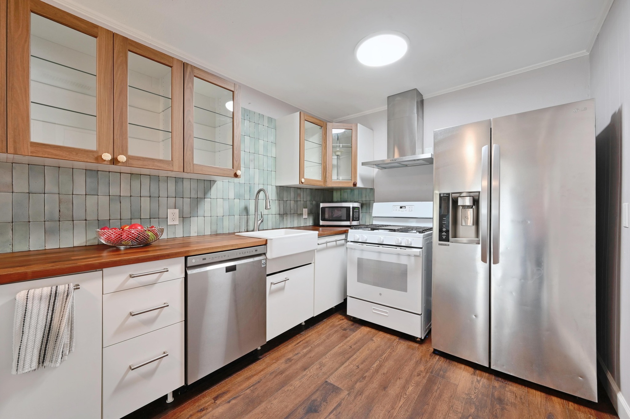 6302 Thurgood Avenue Austin, TX 78721 - Photo 7 of 28 Kitchen with stainless steel appliances, glass insert cabinets, decorative backsplash.