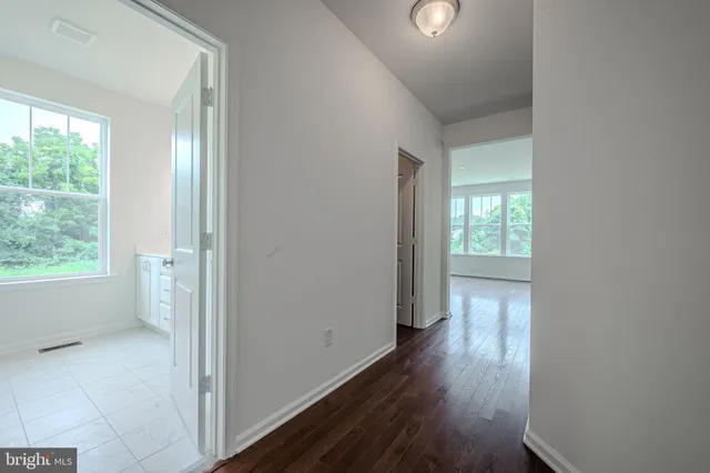 a view of a hallway with wooden floor and windows