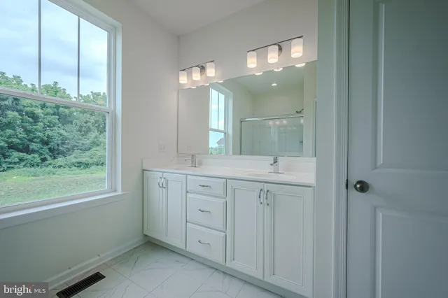 a bathroom with a double vanity sink and a mirror
