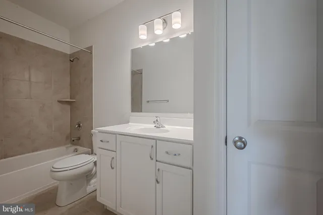 a bathroom with a toilet a sink a mirror a vanity and shower