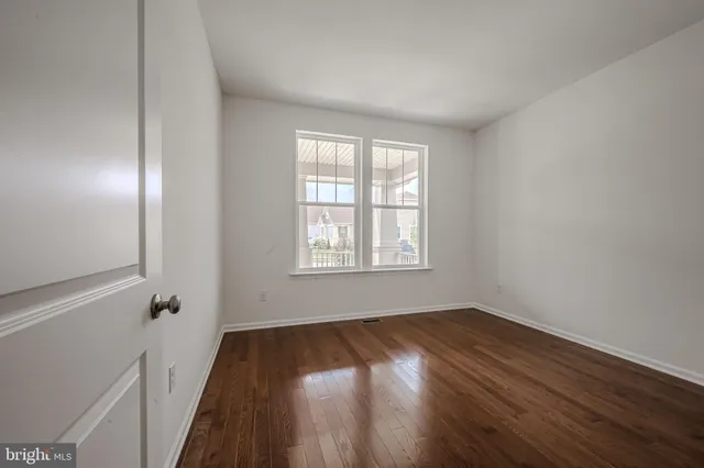a view of a room with wooden floor and window