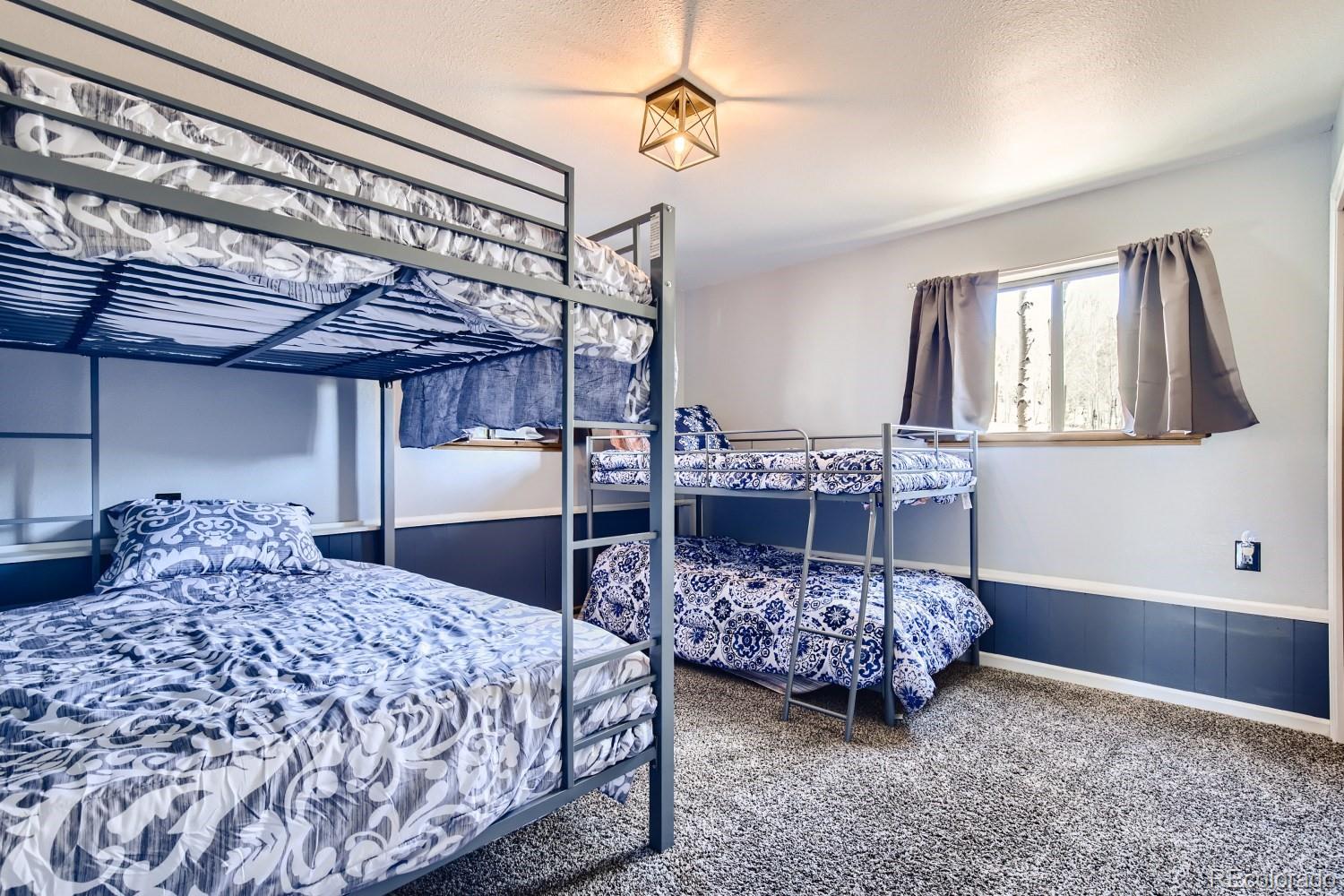 44 Bandit Lane Bailey, CO 80421 - Photo 11 of 30 a bedroom with a bed a chandelier and closet