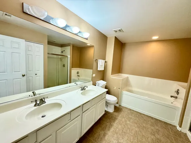 a bathroom with a double vanity sink mirror double and bathtub