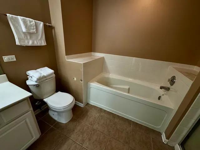 a white toilet sitting next to a white tub