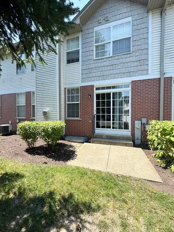 a front view of a house with a yard and potted plants