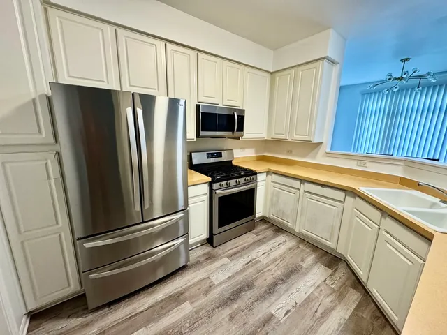 a kitchen with a refrigerator sink and cabinets