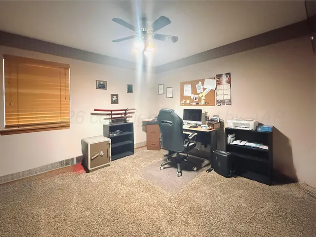 a view of a workspace with furniture and a window