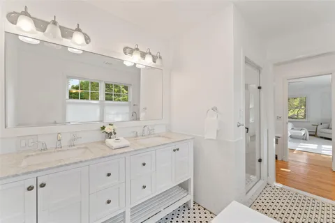 a spacious bathroom with double sink and a mirror