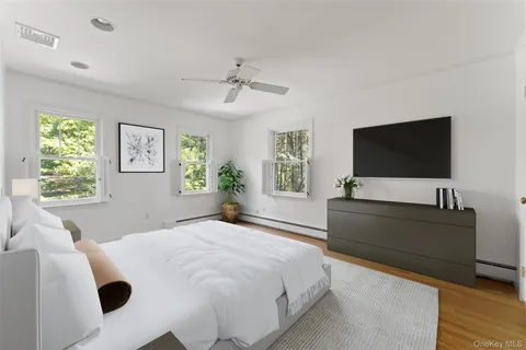 a bedroom with a bed and a flat screen tv on dresser