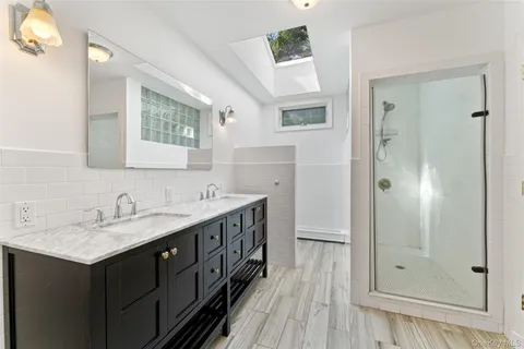 a bathroom with a double vanity sink a mirror and a shower