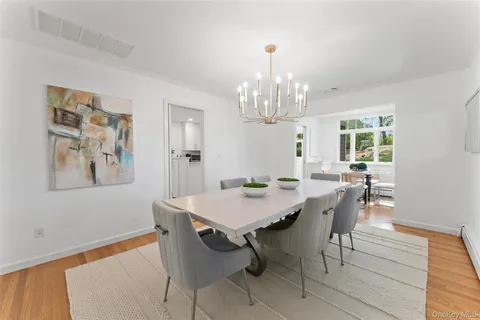 a view of a dining room with furniture a chandelier and wooden floor