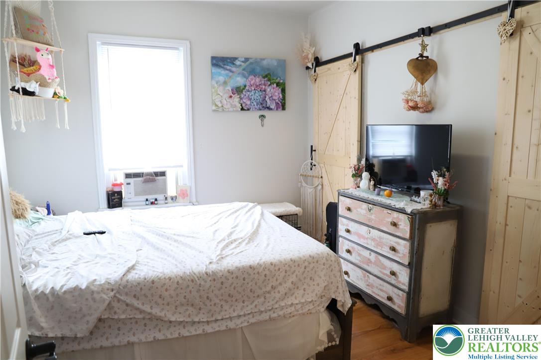 413 Pawnee Street Bethlehem, PA 18015 - Photo 10 of 16 a bedroom with a bed and a flat tv screen on the dresser