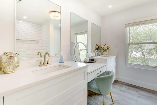 a bathroom with a granite countertop sink a mirror and next to a window