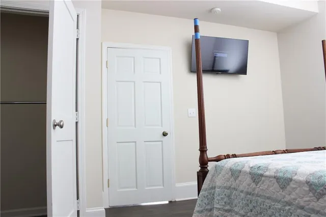 a bedroom with bed and flat tv screen