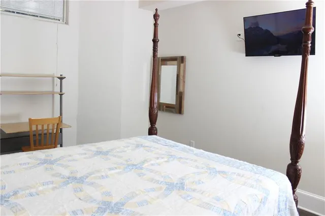 a bedroom with a bed and a flat screen tv