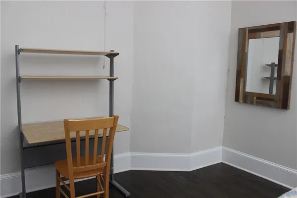a view of a hallway with wooden floor and a cabinet