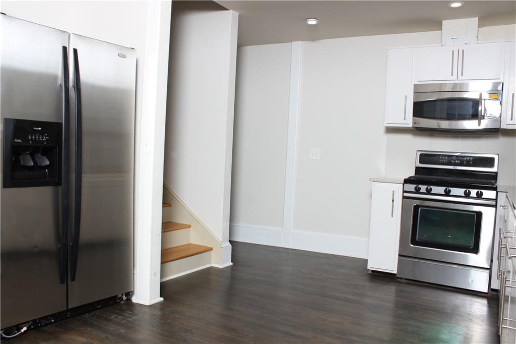 1124 Center Street Northwest Atlanta, GA 30318 - Photo 3 of 20 a kitchen with granite countertop a refrigerator and a stove top oven