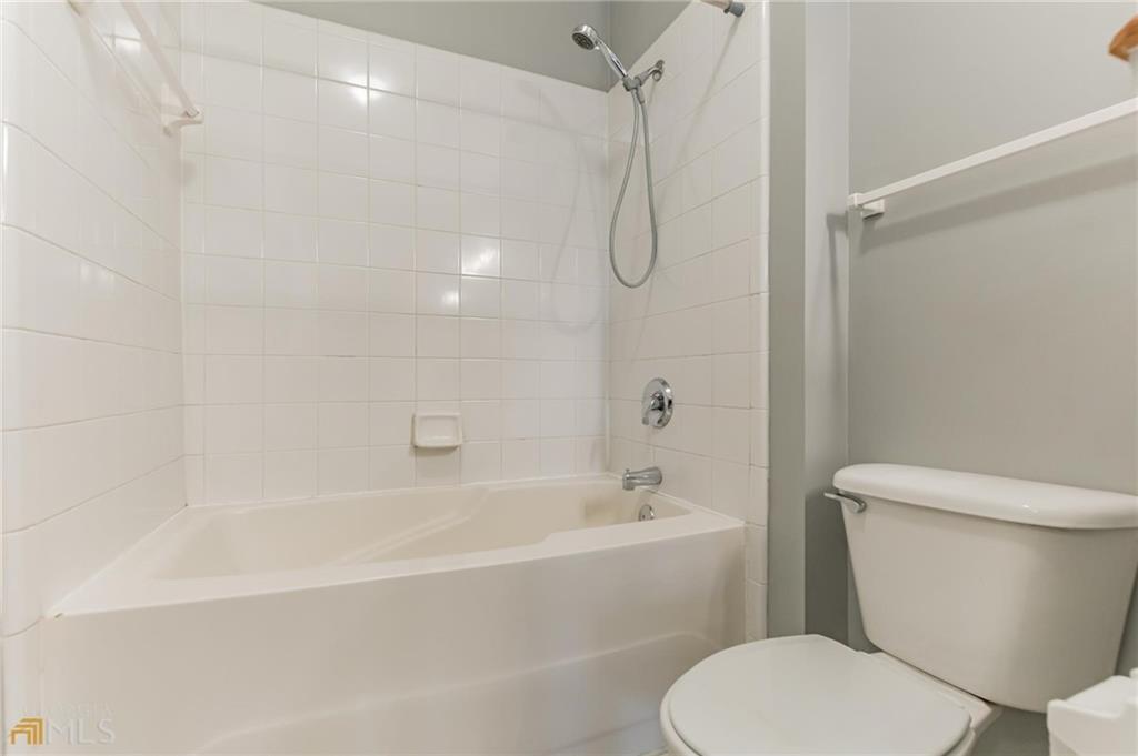 711 Spring Heights Lane, Unit 711 Smyrna, GA 30080 - Photo 14 of 30 a white toilet sitting next to a bath tub and shower