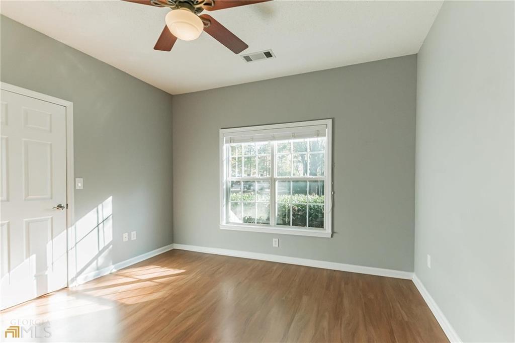 711 Spring Heights Lane, Unit 711 Smyrna, GA 30080 - Photo 17 of 30 an empty room with wooden floor chandelier fan and windows