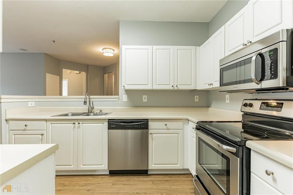711 Spring Heights Lane, Unit 711 Smyrna, GA 30080 - Photo 7 of 30 a kitchen with stainless steel appliances granite countertop a sink and a stove