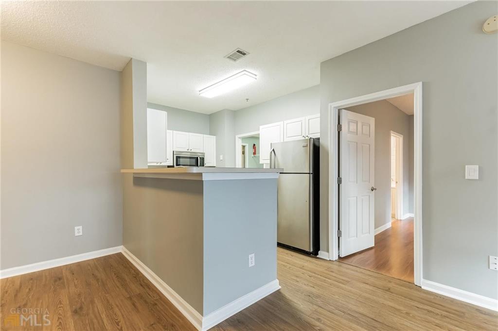 711 Spring Heights Lane, Unit 711 Smyrna, GA 30080 - Photo 9 of 30 a view of a kitchen with refrigerator and wooden floor