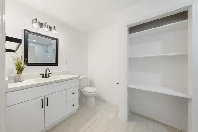 a bathroom with a toilet sink and mirror