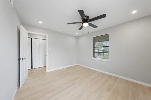 a view of a big room with wooden floor closet and windows