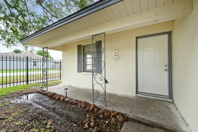 a view of a house with a floor to ceiling window and wooden fence