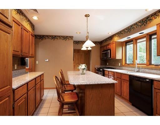 120 Quinobequin Road Newton, MA 02468 - Photo 6 of 8 a kitchen with stainless steel appliances kitchen island granite countertop a table chairs in it and wooden floors