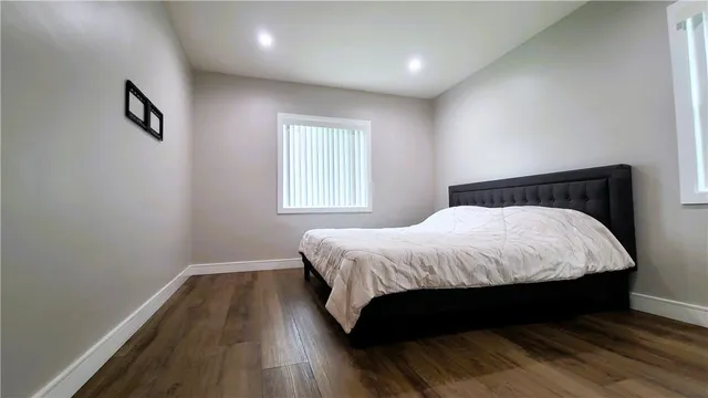 a large bed sitting in a bedroom next to a window