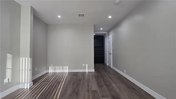 a view of an empty room with wooden floor