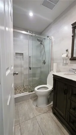 a bathroom with a granite countertop sink toilet and shower