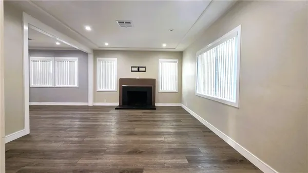 a view of empty room with wooden floor and fireplace
