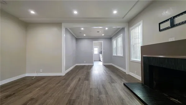 an empty room with wooden floor and a fireplace