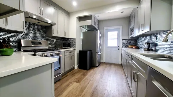 a kitchen with a sink a counter top space stainless steel appliances and cabinets