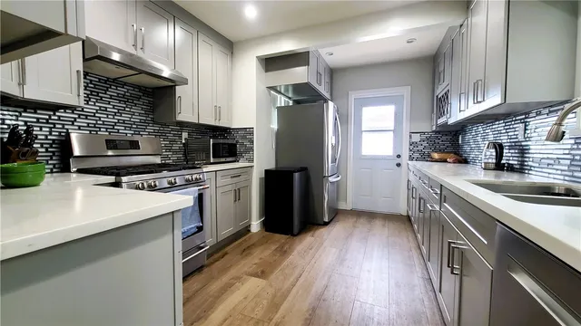 a kitchen with a sink a counter top space stainless steel appliances and cabinets