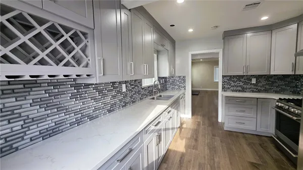 a kitchen with stainless steel appliances granite countertop a stove a sink and a refrigerator