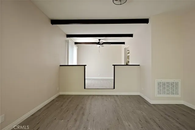 an empty room with wooden floor and cabinet