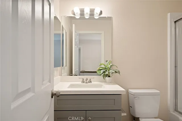 a bathroom with a sink and mirror with toilet