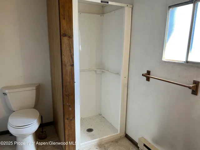 a bathroom with a toilet and a shower